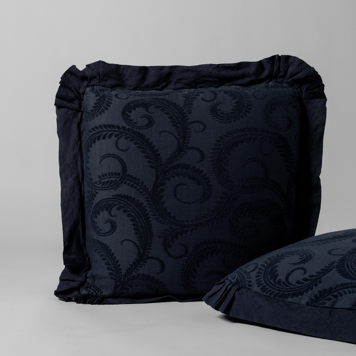 Slate Marisette sham showing ruffled edge and tone-on-tone scrolling embroidery detail.