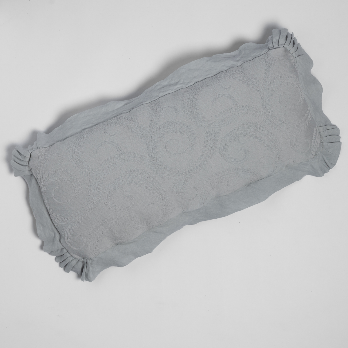 Cloud colorway Marisette throw pillow, ruffled edges and scrollwork texture, angled view.