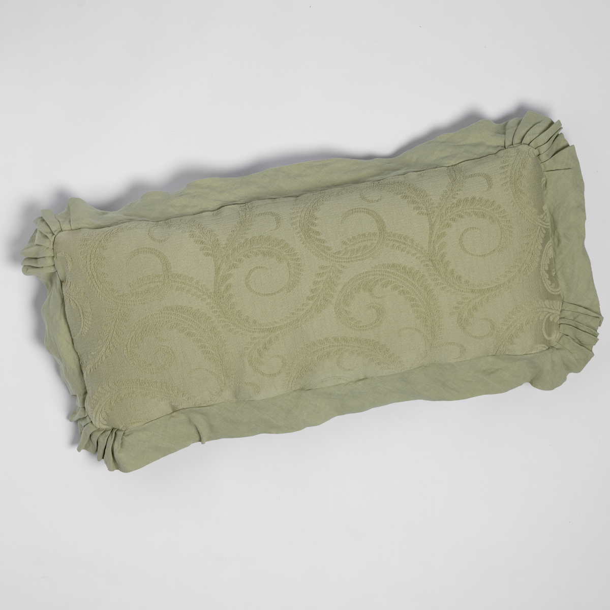 Desert Sage Marisette throw pillow showing ruffled trim and tonal scroll embroidery detail.