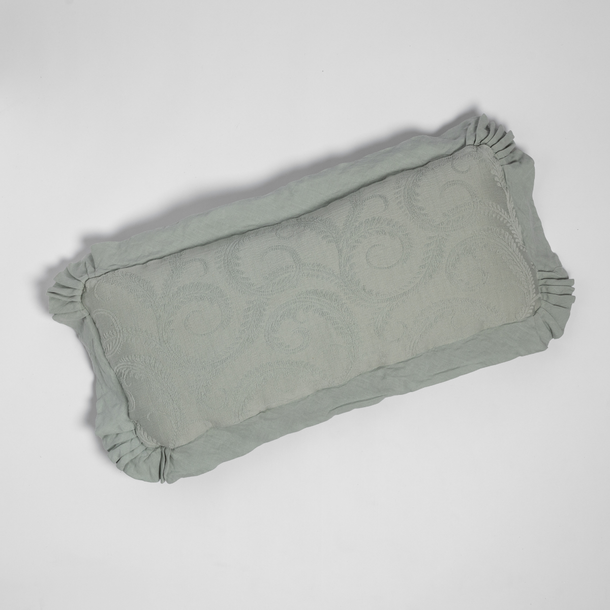 Eucalyptus Marisette throw pillow showing ruched corners and tone-on-tone scroll pattern, overhead view.