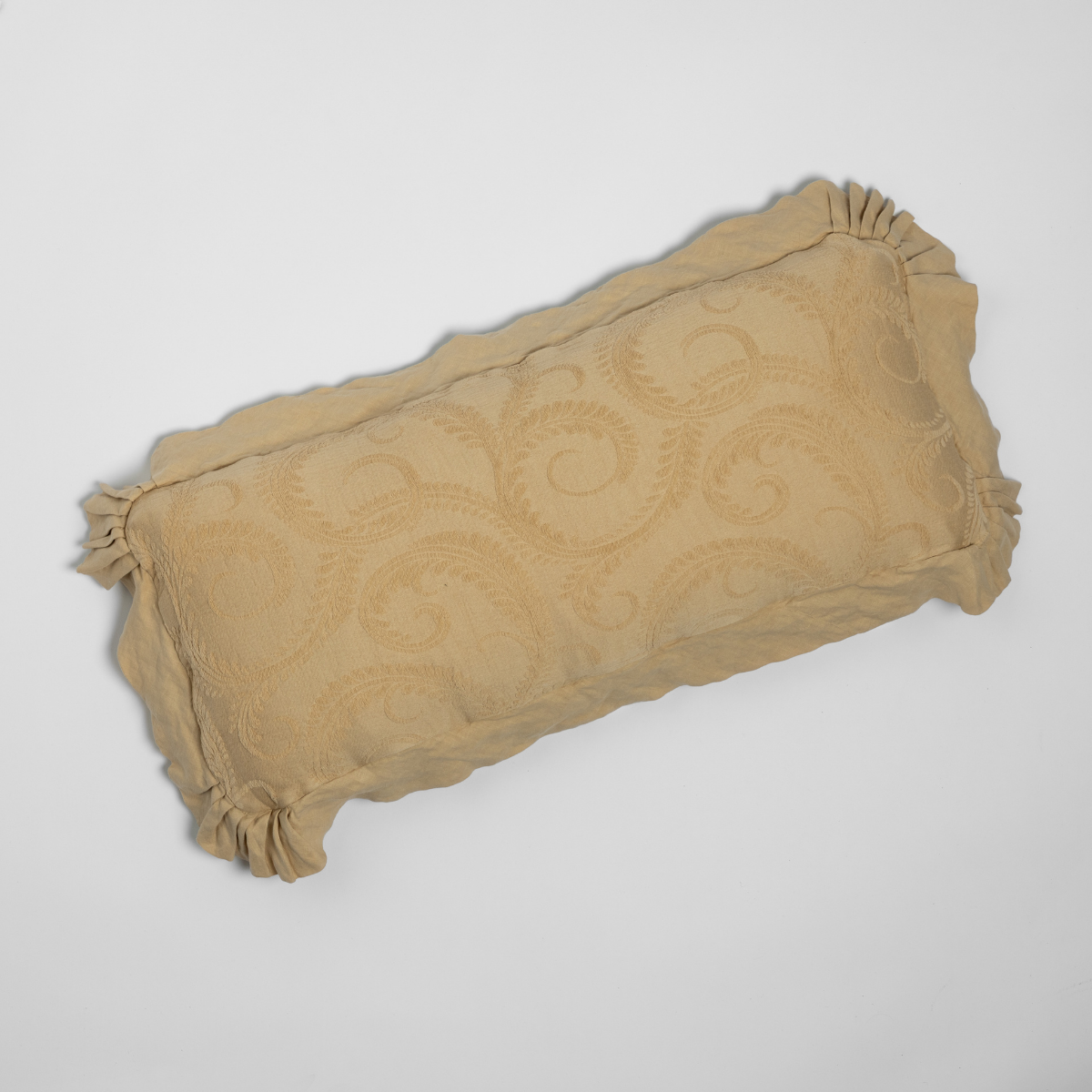 Honeycomb Marisette throw pillow showing scrollwork jacquard pattern and ruffled edges.