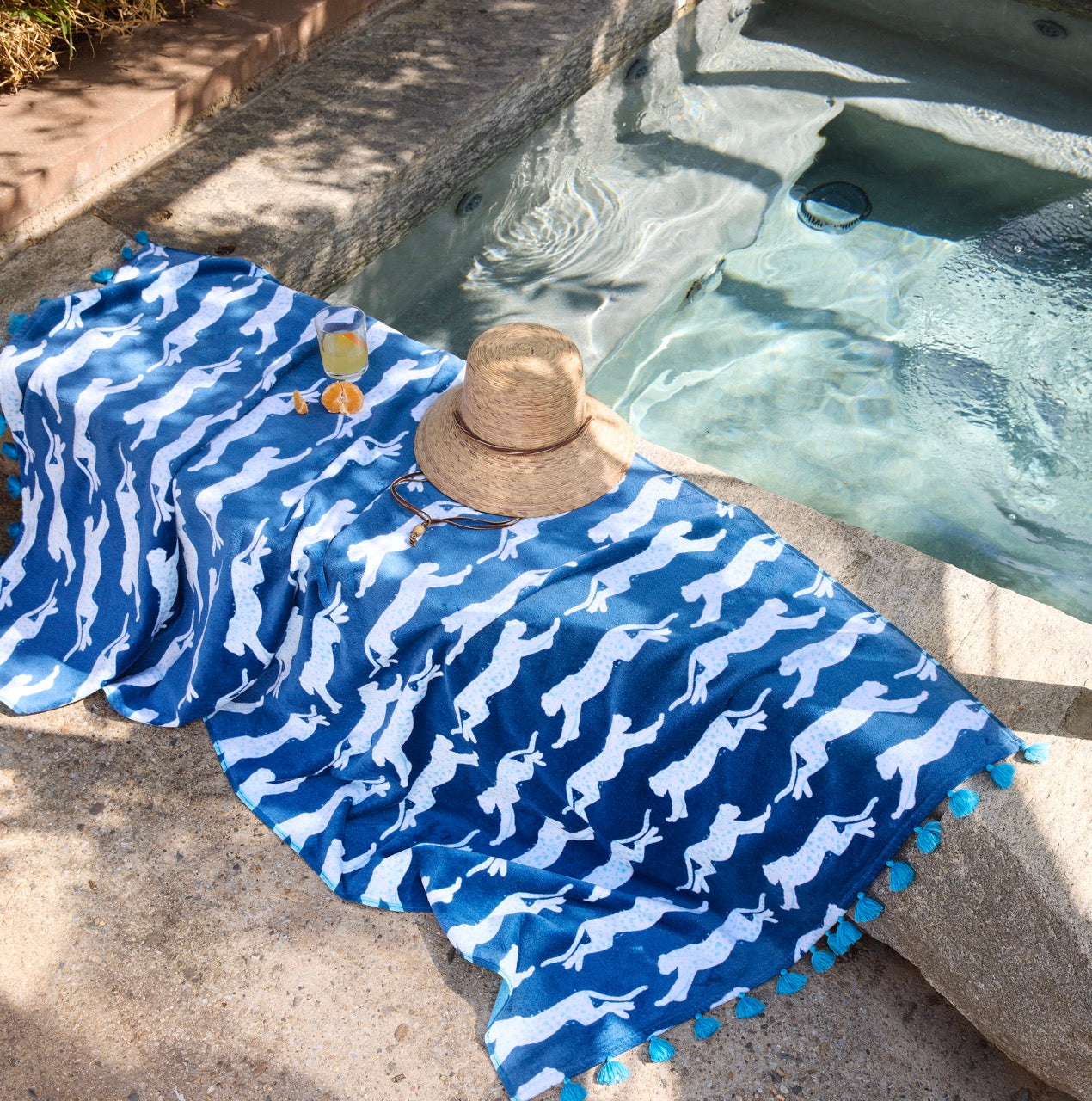 Image of Matouk Leaping Leopard Navy Beach Towel by a pool