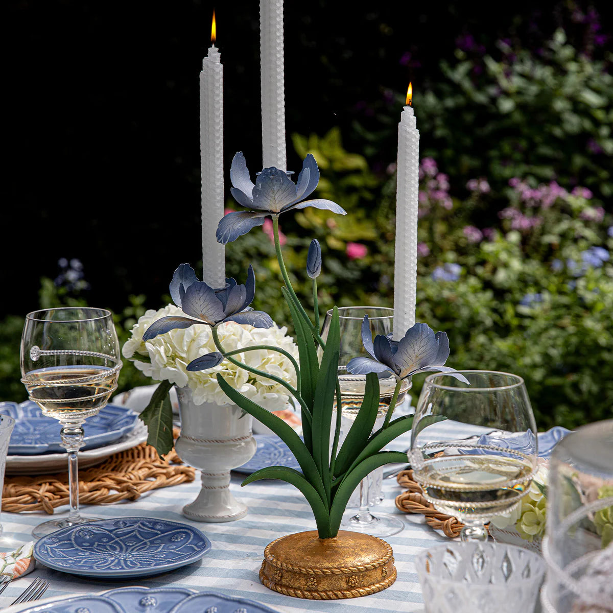 Juliska Meadow Walk candelabra with navy iris blooms styled on an outdoor garden tablescape.