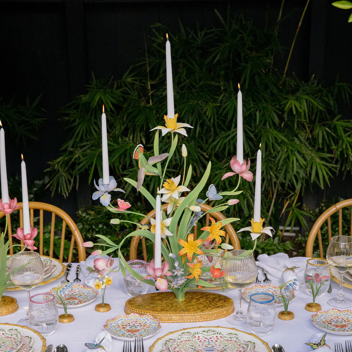 Floral candelabra centerpiece styled on a tablescape with taper candles and garden greenery.