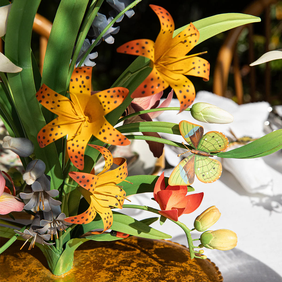 Close-up of hand-painted tiger lilies and butterfly detail on the Meadow Walk candelabra.