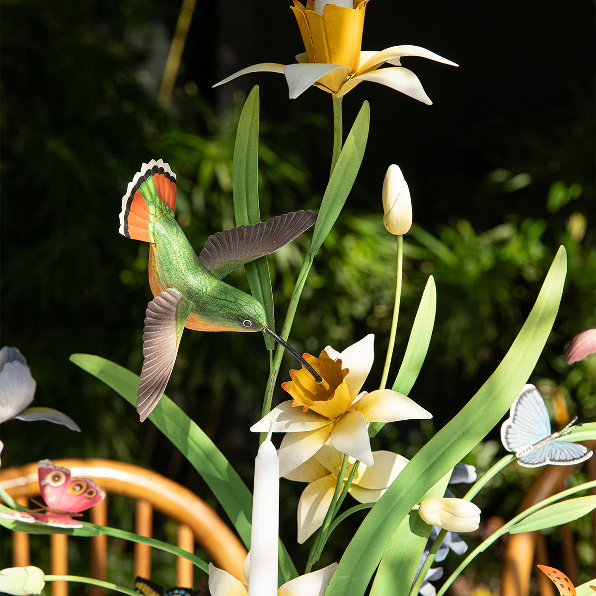 Close-up of paper-craft hummingbird and daffodils on Meadow Walk candelabra.