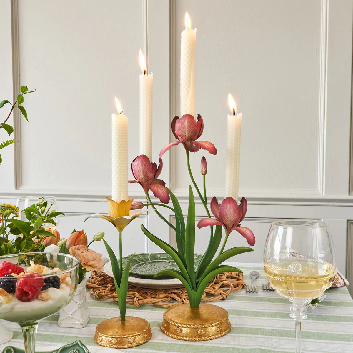 Juliska Meadow Walk candelabra with lit ivory tapers styled on a green-striped tablescape.