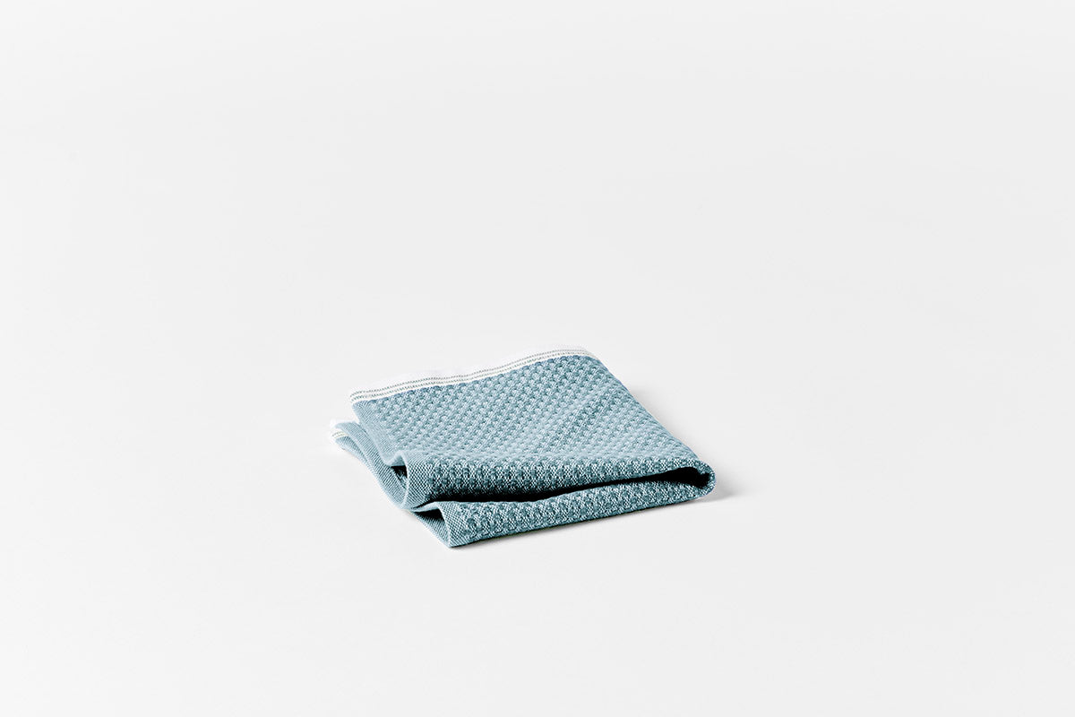 Close-up of folded seafoam Coyuchi Mediterranean bath towel showing waffle-weave texture.