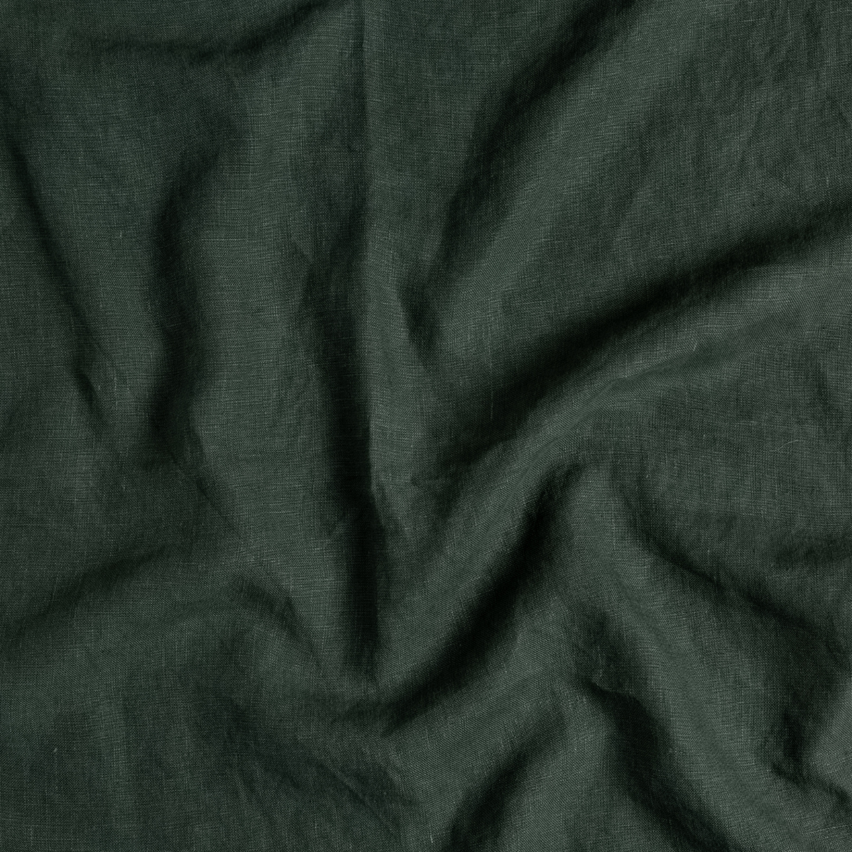 Close-up of Bella Notte Austin bed skirt in Juniper, showing draped linen texture and folds.