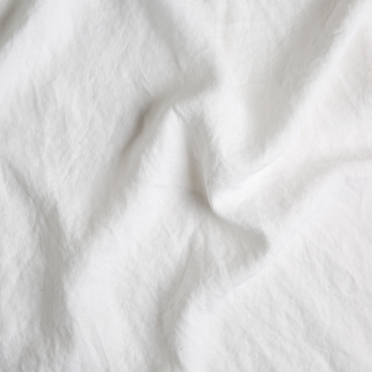 Close-up of White Austin throw pillow fabric showing soft linen texture and natural drape.