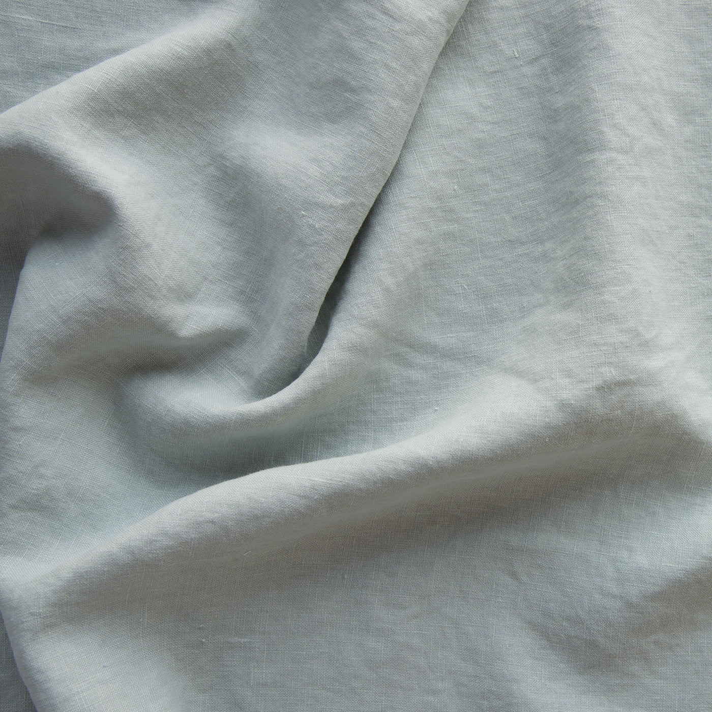 Close-up of Bella Notte Austin sham in Eucalyptus, showing soft draped linen weave texture.