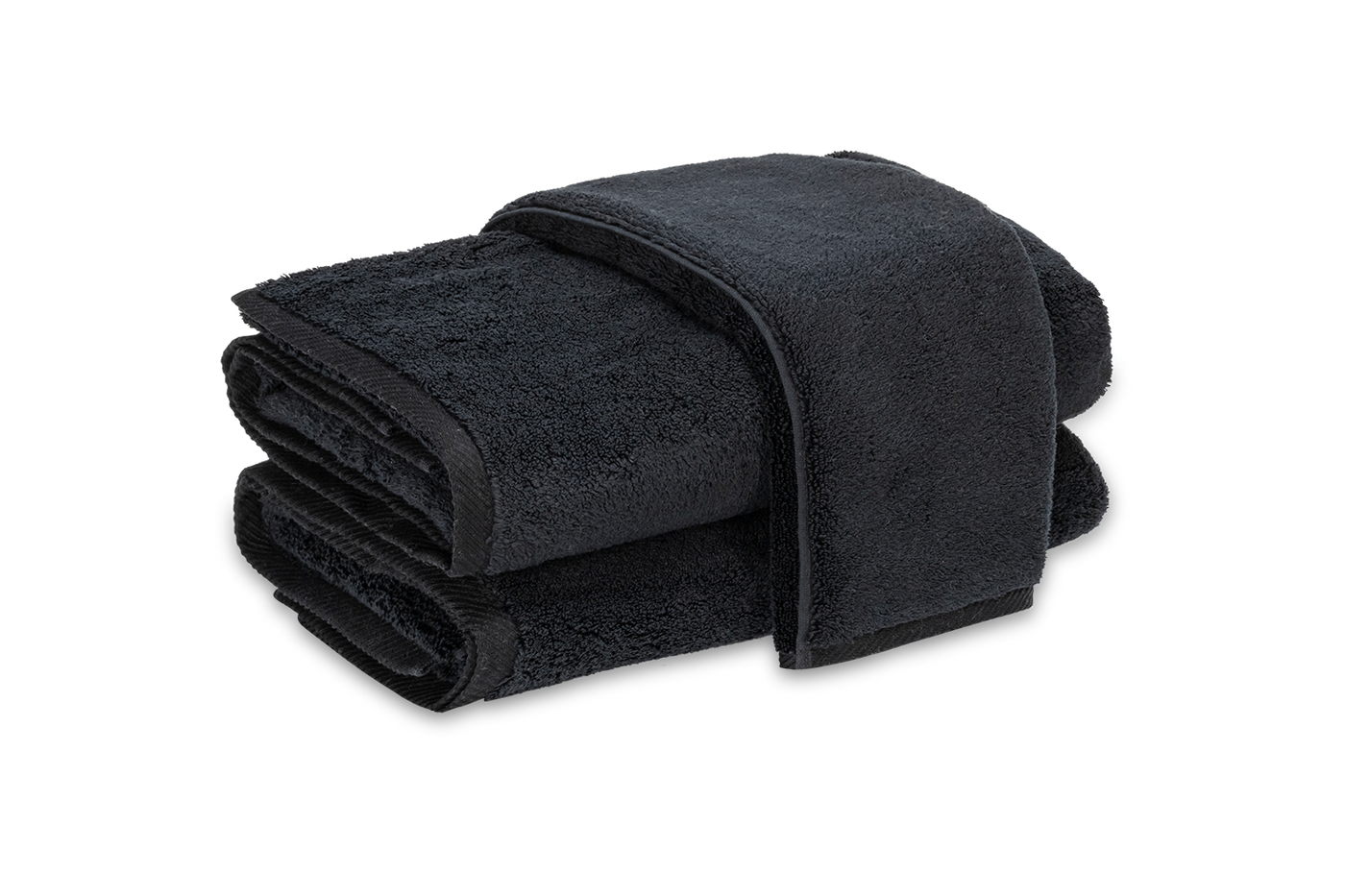 Folded onyx Matouk Milagro bath sheets stacked, showing dense terry texture.