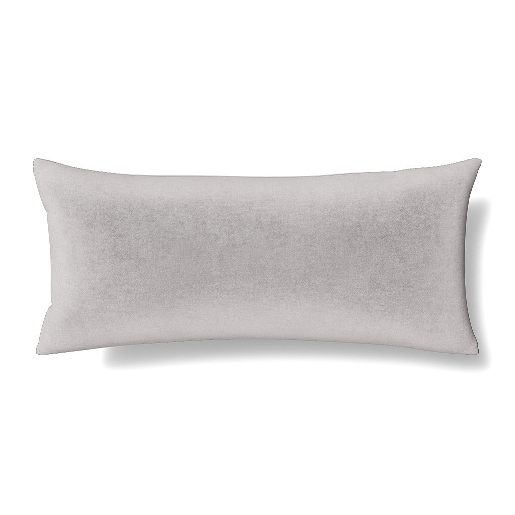 Side angle view of a silver-grey velvet lumbar pillow, plump and softly filled.