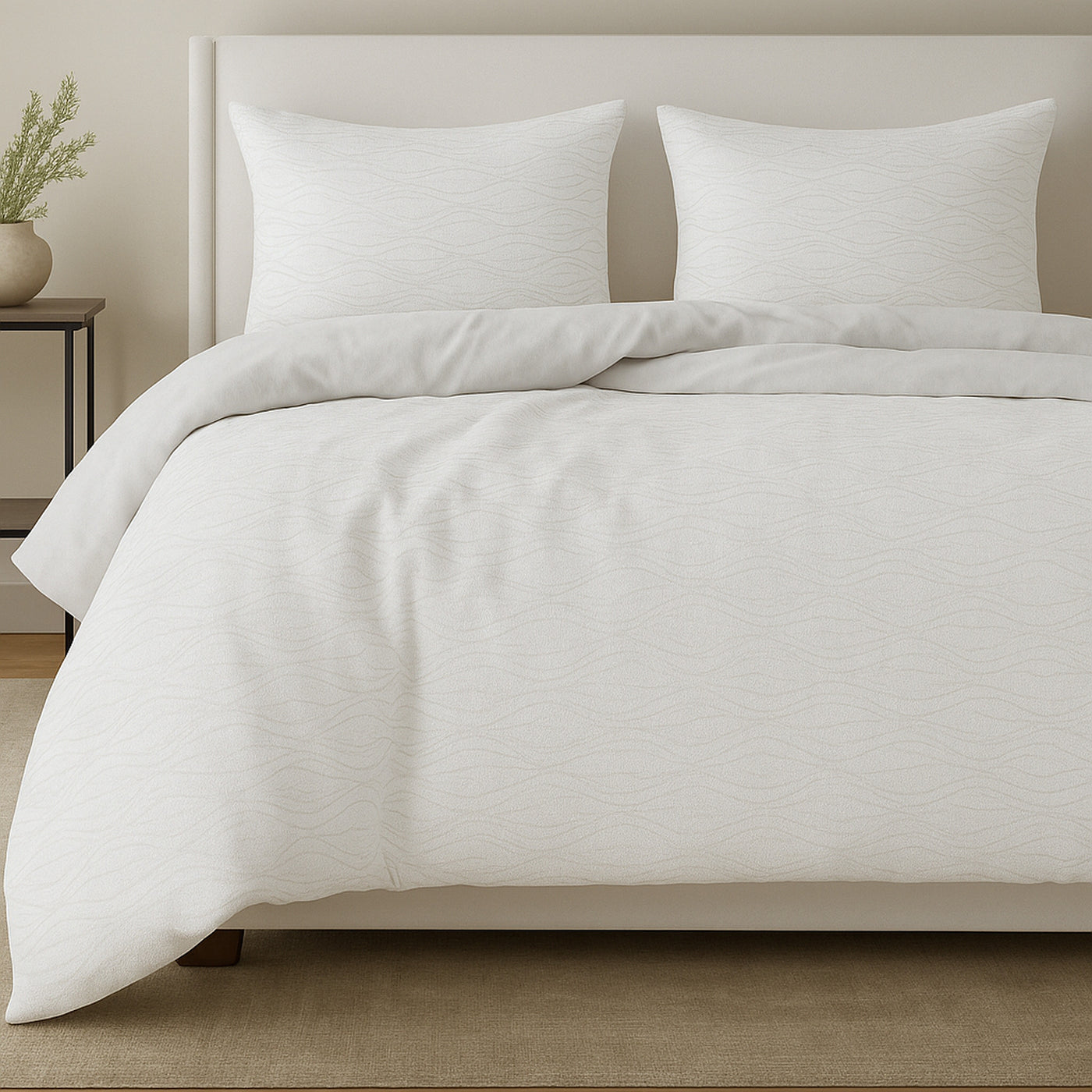Ann Gish Moonstone comforter set in ivory, styled on bed with two shams, subtle textured weave detail.