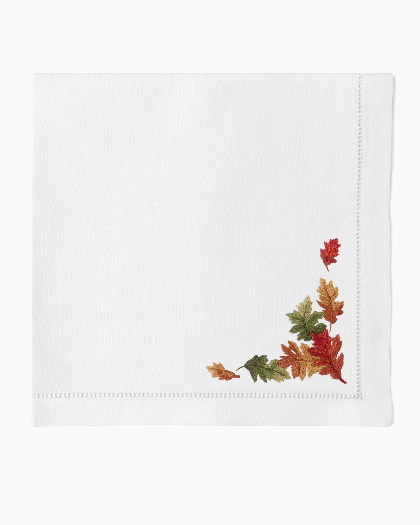 Henry Handwork Fall Leaves white linen dinner napkin with embroidered autumn leaves corner detail.