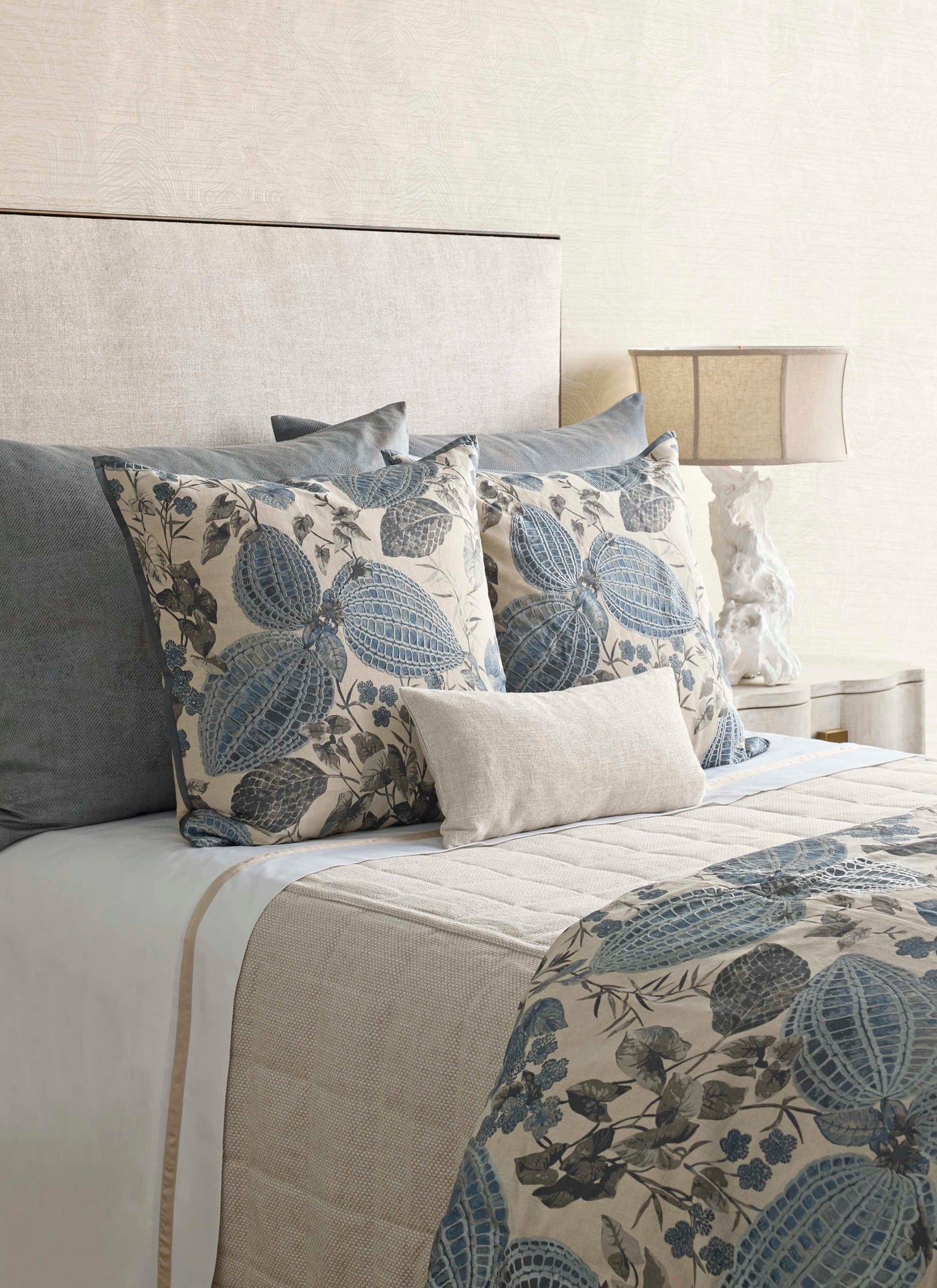 Styled bed showing Ann Gish Nature duvet's blue botanical leaf print against ivory linen.