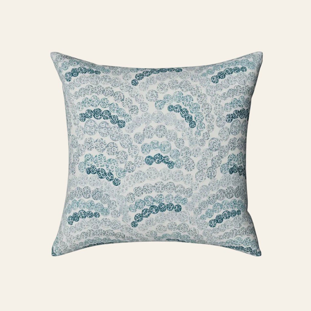 Ann Gish Nazar pillow with teal wave pattern on ivory ground.