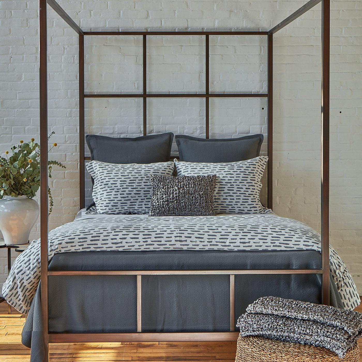 Ann Gish Neo matelasse coverlet set in slate, styled on a four-poster bed with coordinating pillows.