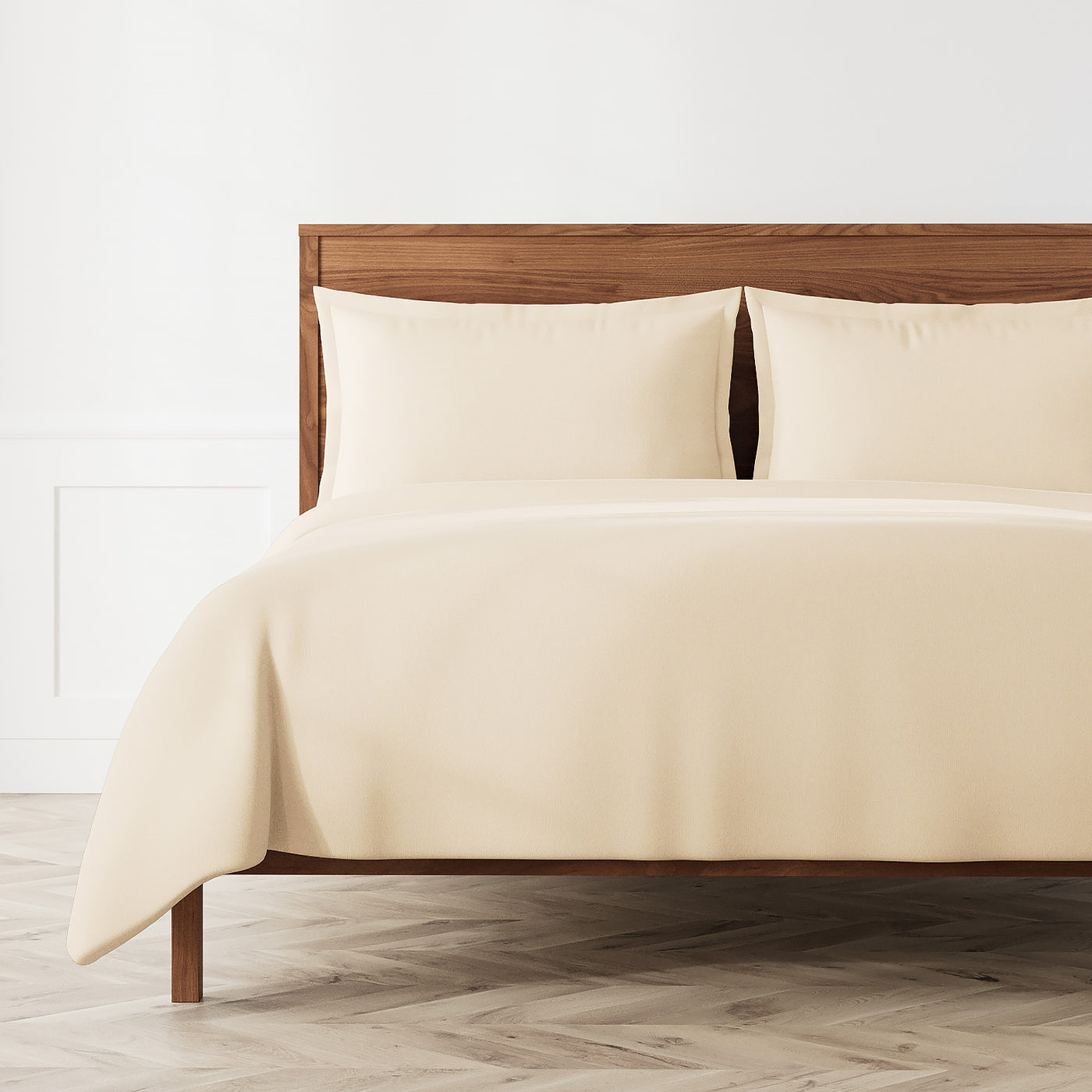 Ann Gish Neo duvet set in ivory styled on a wood-frame bed with matching pillowcases.