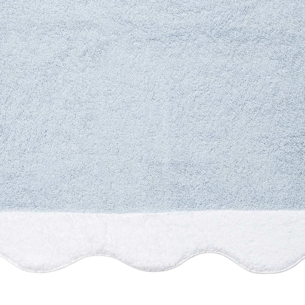 The Neptune | Pool Towel by Matouk features light blue textured fabric and a scalloped white edge, offering absorbent Cairo cotton that's perfect for poolside use.
