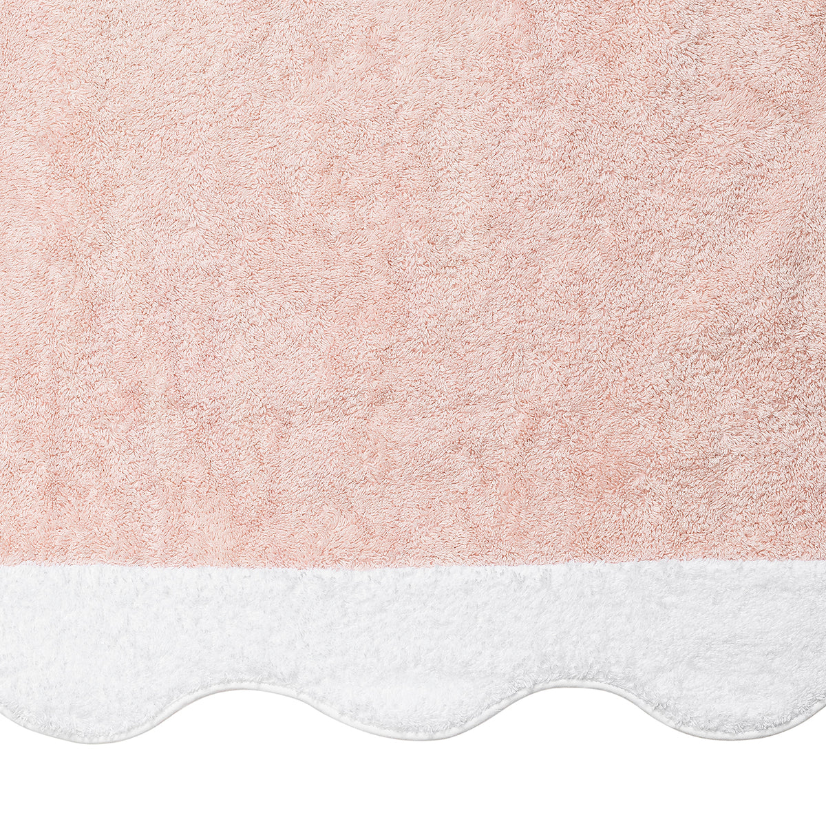 A close-up of the Matouk Neptune | Pool Towel in pink, featuring a white scalloped edge, highlights its ultra-soft, absorbent texture.