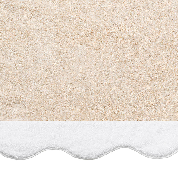 The Neptune | Pool Towel by Matouk is a beige, absorbent towel with a white scalloped edge at the bottom, perfect for use as a mat or pool towel on any flat surface.