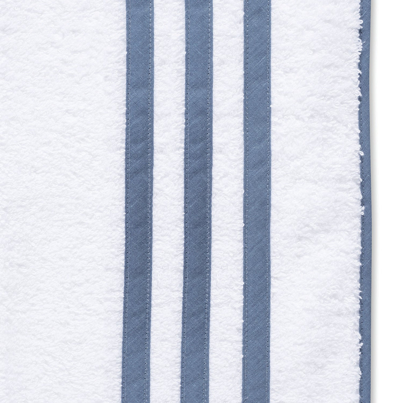The Matouk Newport Shower Curtain features a white textured design with three vertical blue stripes on the right, inspired by classic diamond pique bath linens.