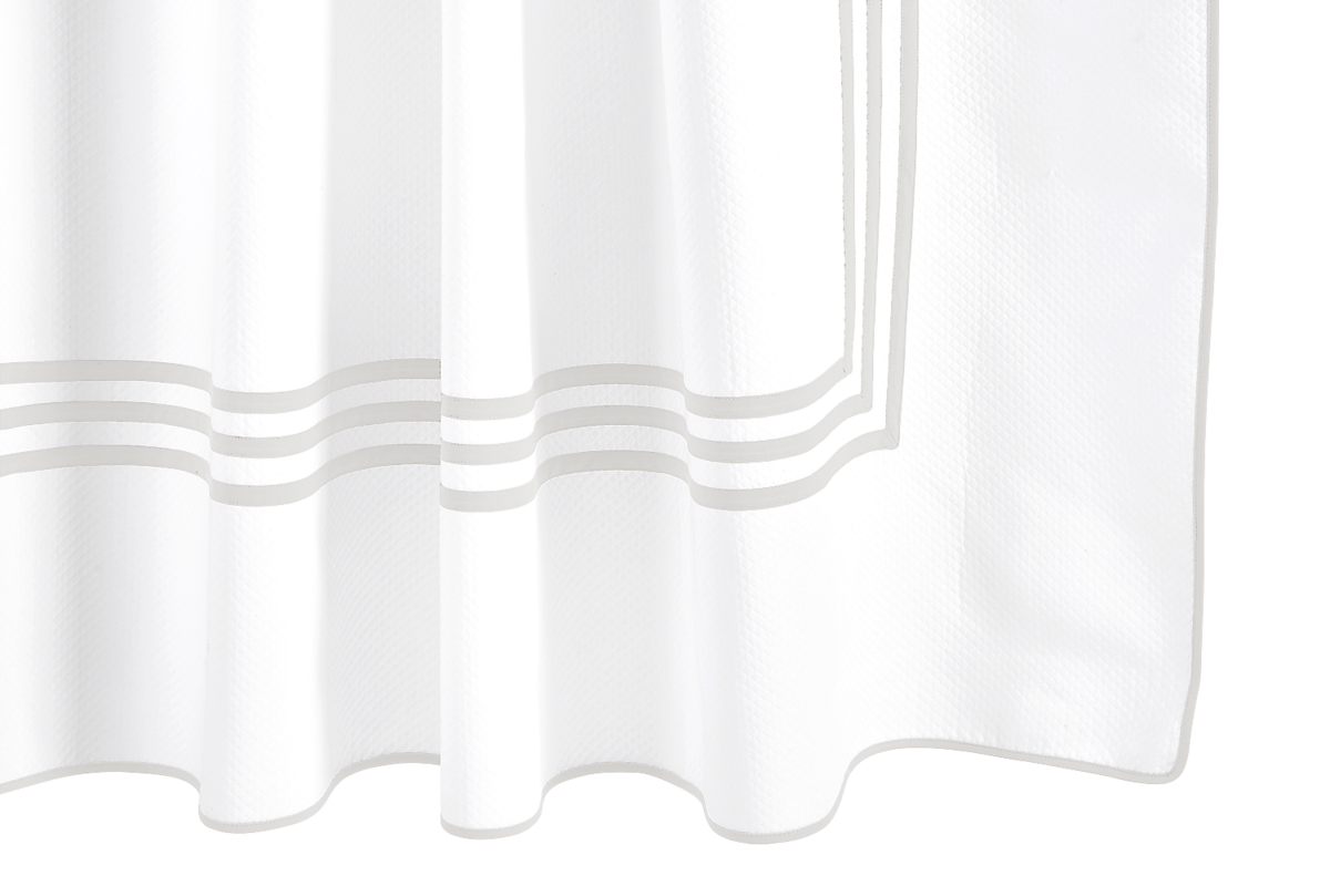 Close-up of the Matouk Newport Shower Curtain in white, designed with three gray horizontal stripes near the bottom—a stylish enhancement to your bath linens collection.