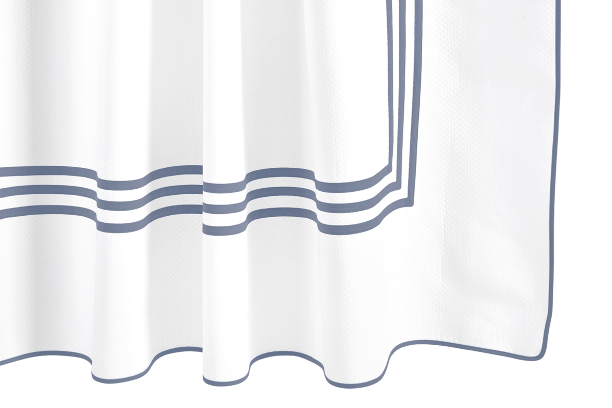 The Matouk Newport Shower Curtain features white diamond pique fabric with three parallel navy blue stripes from triple appliqué tape and a matching navy border; the fabric has a subtle pleated appearance.