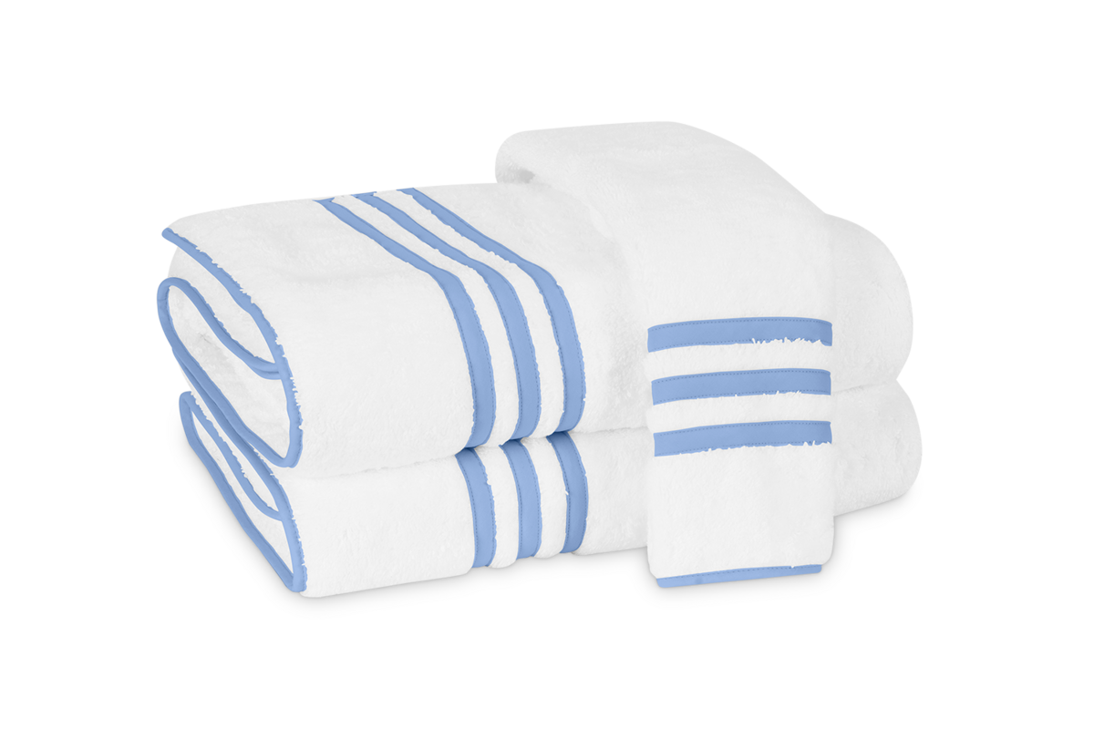 Two neatly folded Newport Bath Towels by Matouk, featuring blue stripes and appliqué-tape borders, highlight the elegance of Cairo cotton terry—perfect for adding sophistication to any bathroom.