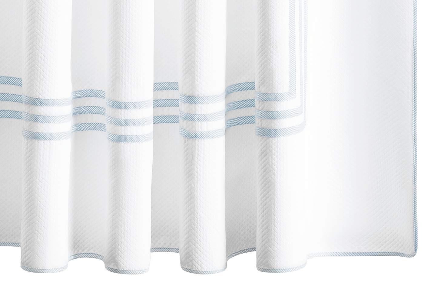 The Matouk Newport Shower Curtain features white fabric with a subtle herringbone texture and three light blue horizontal stripes near the bottom—an elegant bath linen upgrade.