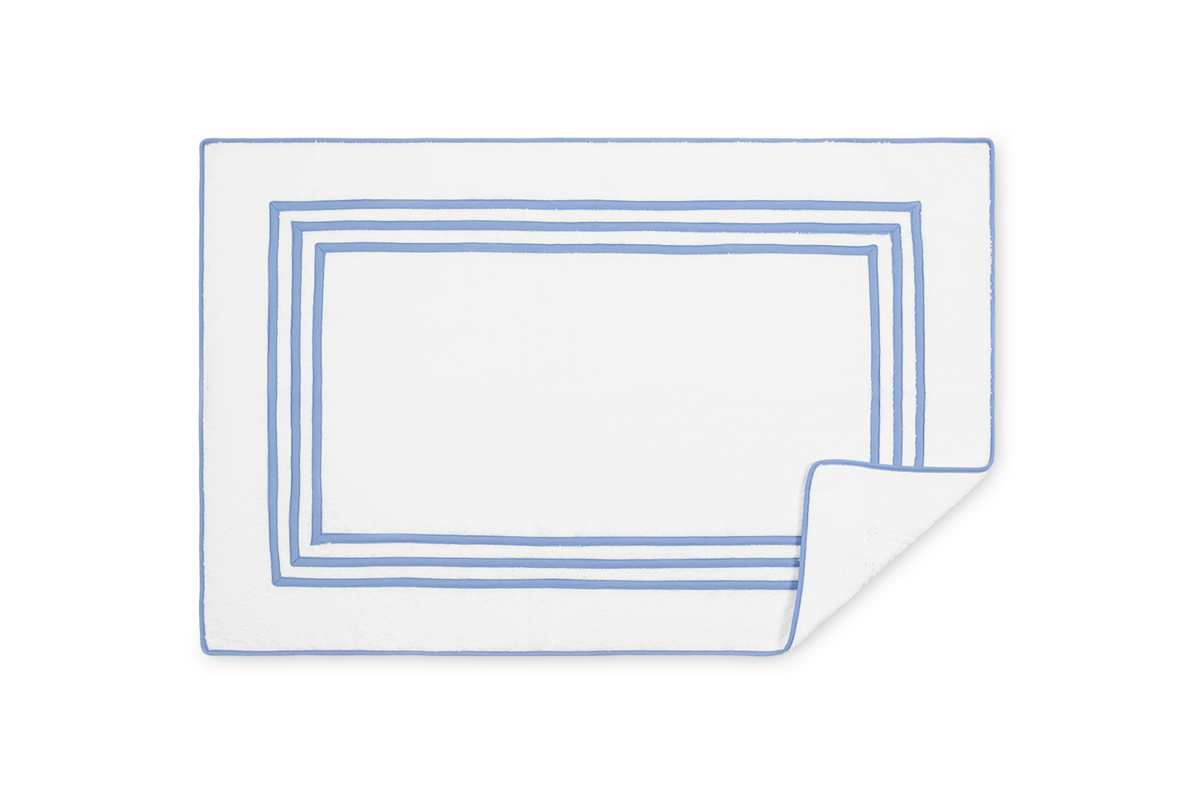 Corner curl detail on Matouk Newport tub mat showing periwinkle border and white reverse.