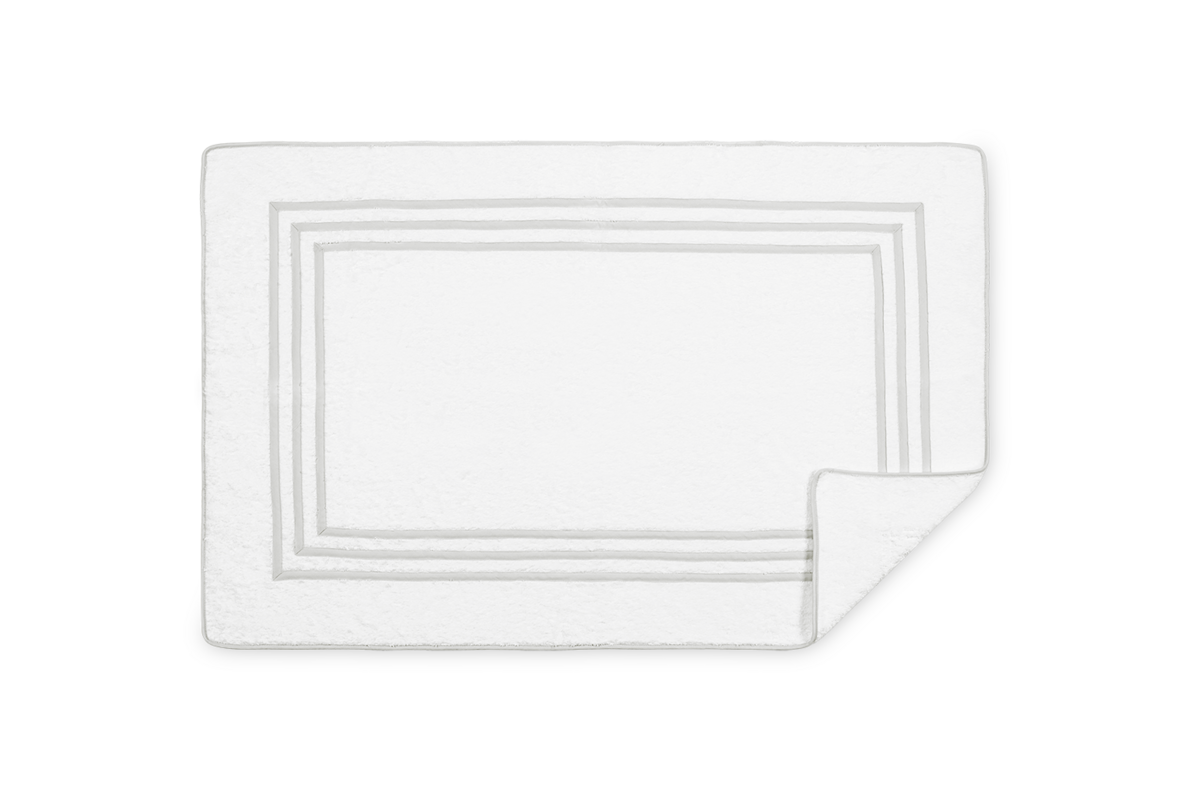 Corner fold detail on white Matouk Newport tub mat with silver-grey triple border.