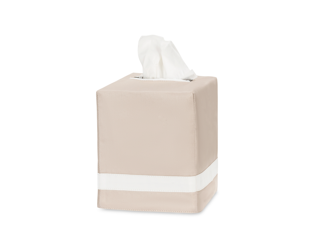 The Matouk Nocturne Tissue Box Cover in beige features a white stripe near the bottom and dispenses tissues from the top, bringing a touch of elegance to your home decor on any plain white background.
