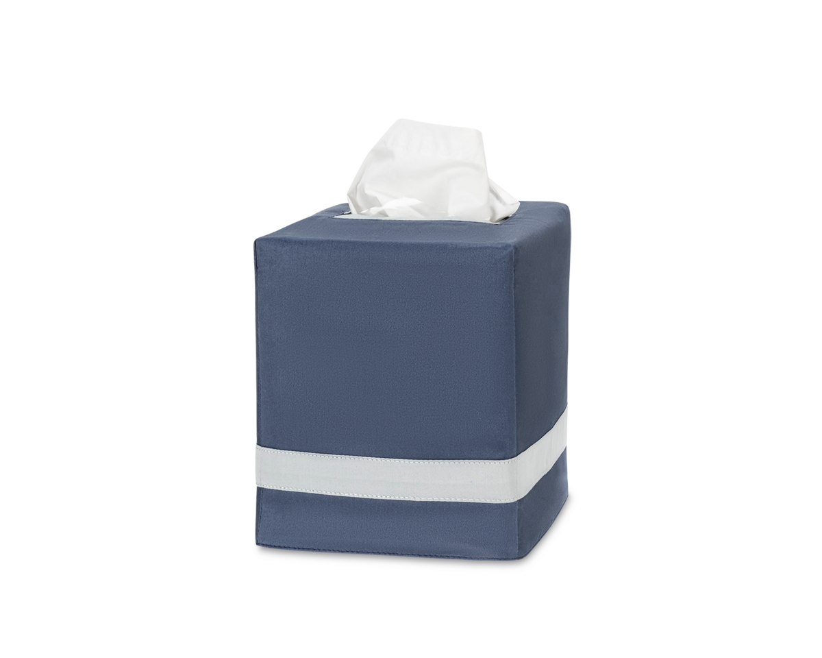 The Nocturne | Tissue Box Cover by Matouk features a blue square design with a white stripe near the bottom and a tissue peeking out, ideal for enhancing your home decor. Shown against a plain white background.