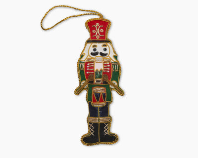 Henry Handwork embroidered nutcracker ornament in red, green, and navy with gold trim.