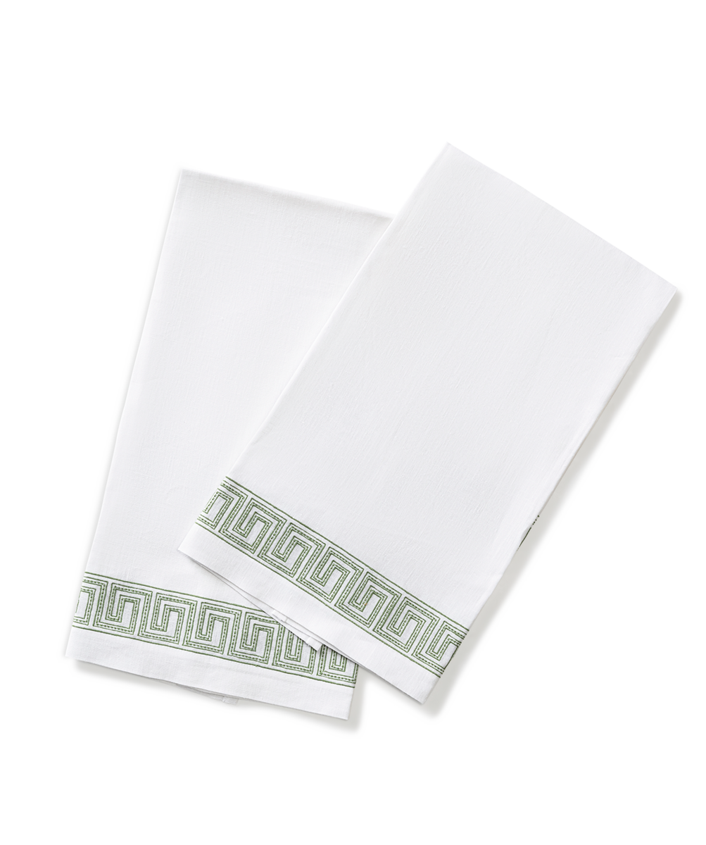 Two folded Ophelia | Embroidered Guest Towels by Matouk, white with a green Greek key pattern on one edge, displayed on a white background.