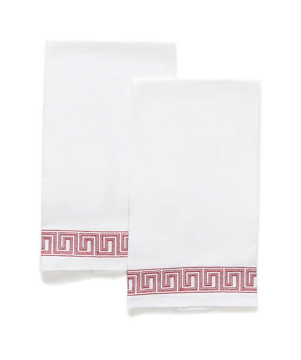 The Ophelia Embroidered Guest Towel Set by Matouk features two white linen towels with red geometric borders, laid flat on a plain background, evoking the look of classic Greek key designs.