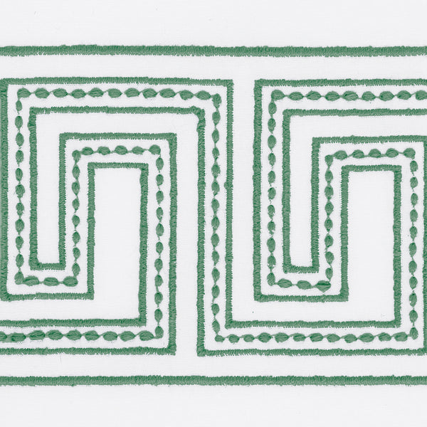 The Ophelia Shower Curtain by Matouk features a green geometric Greek key pattern with dotted and solid lines embroidered on white linen.