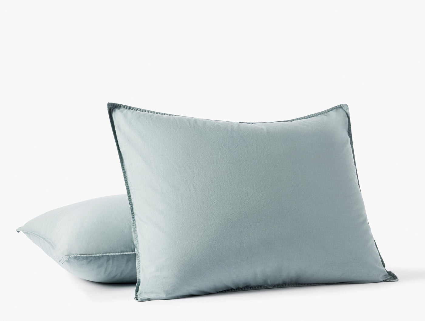 Two stacked seafoam Coyuchi Crinkled Percale shams showing blanket-stitch edge detail.