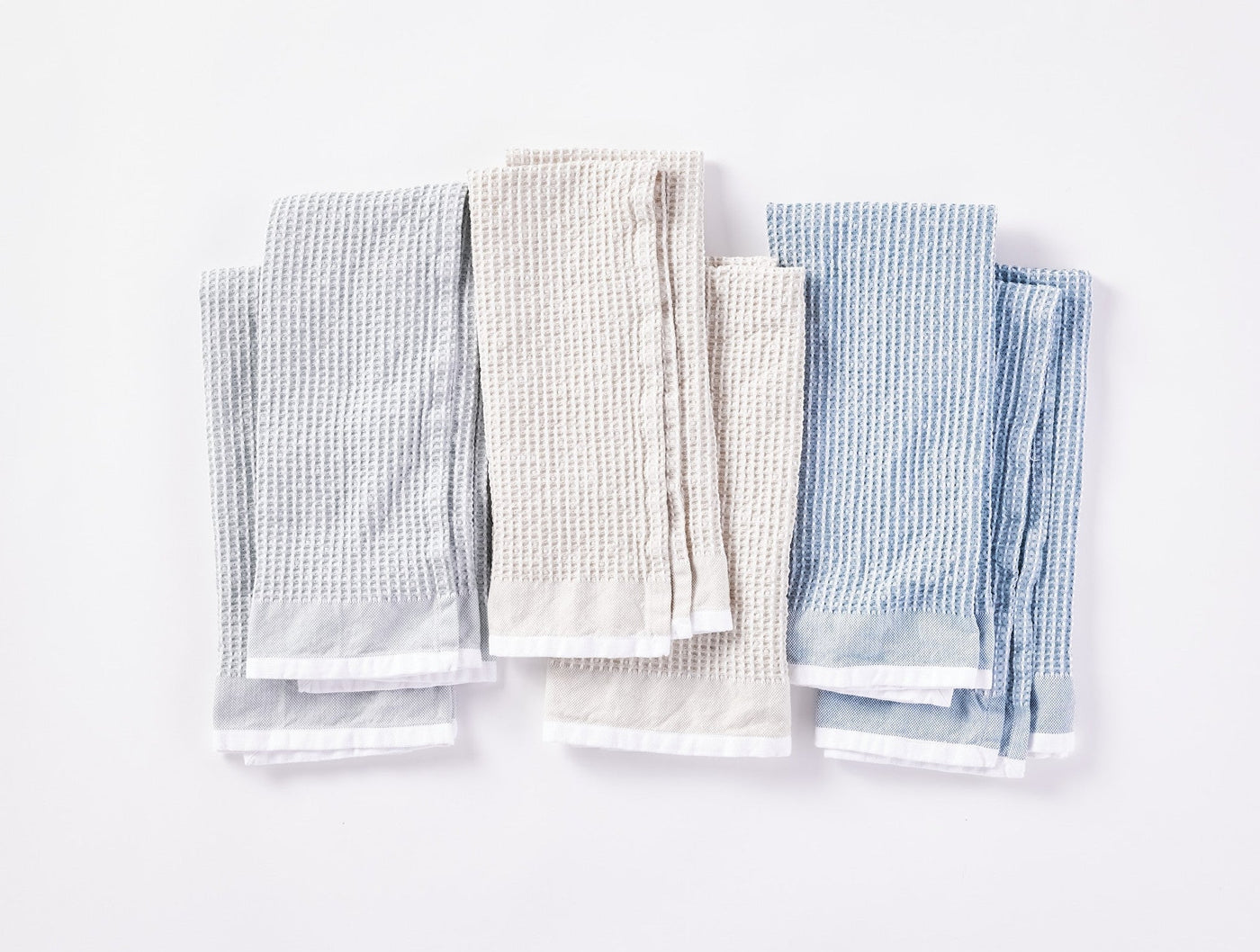 Coyuchi Waffle kitchen towels in fog and natural, flat lay showing all six folded towels.