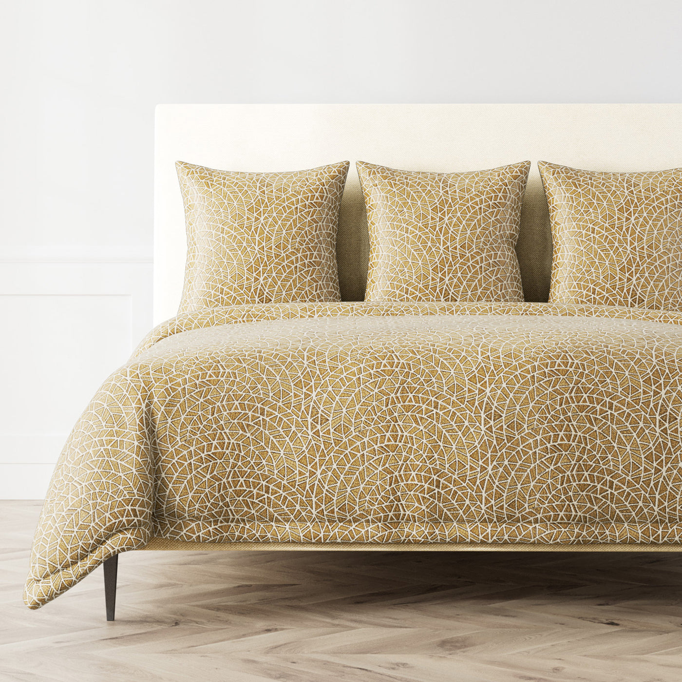 Ann Gish Ornament duvet cover in gold, styled on a bed with matching shams.