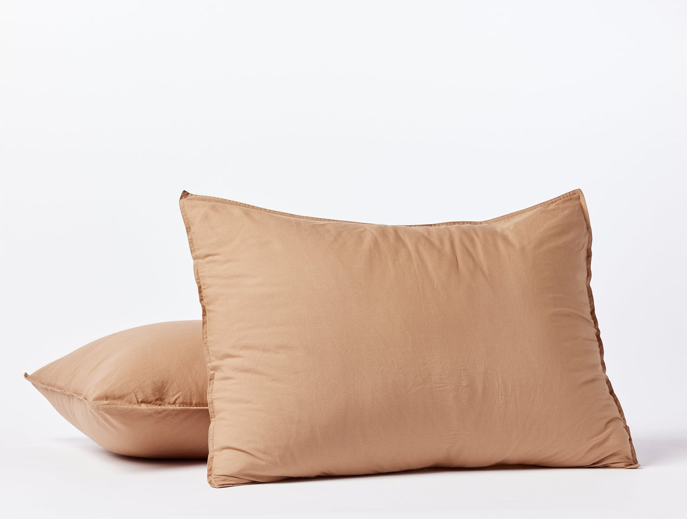 Two caramel crinkled percale pillow shams stacked against a white background.