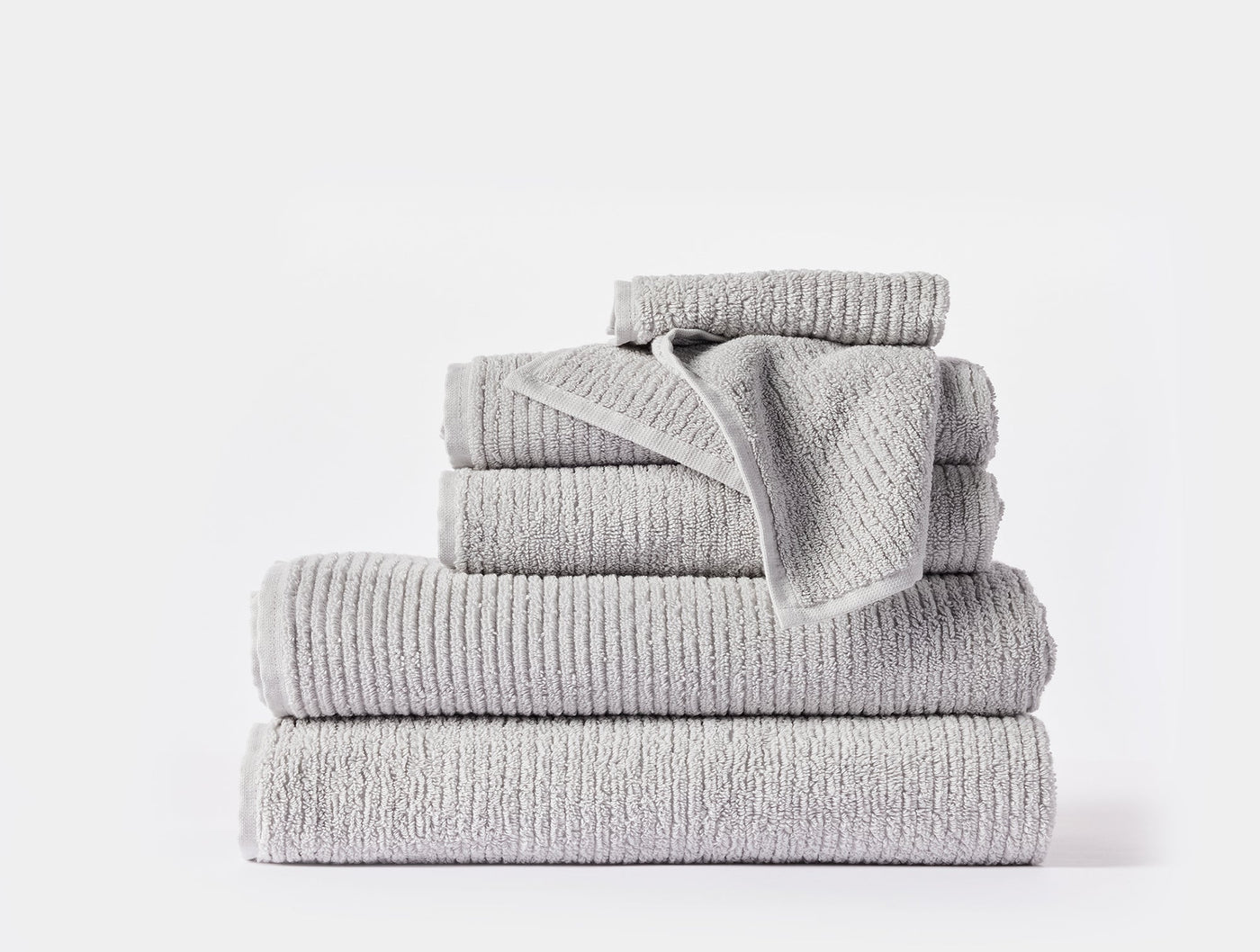 Coyuchi Temescal Ribbed towels stacked in silver grey, ribbed texture detail visible.