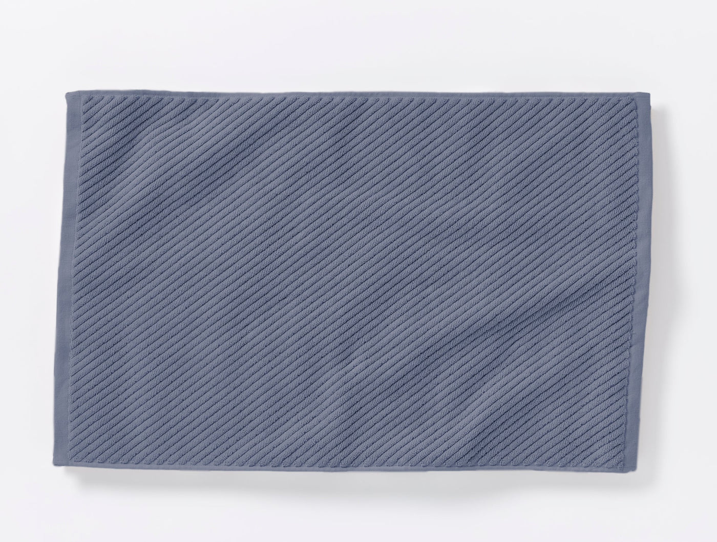 Coyuchi Air Weight bath rug in slate blue, diagonal ribbed twill texture, flat lay.