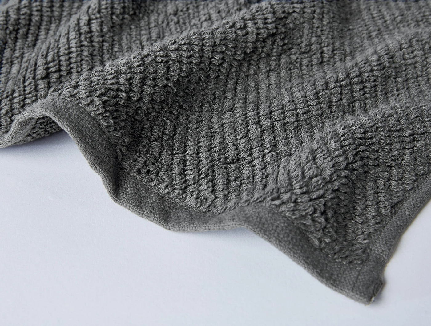 Close-up of Coyuchi Air Weight wash cloth hem in charcoal, showing textured waffle weave detail.