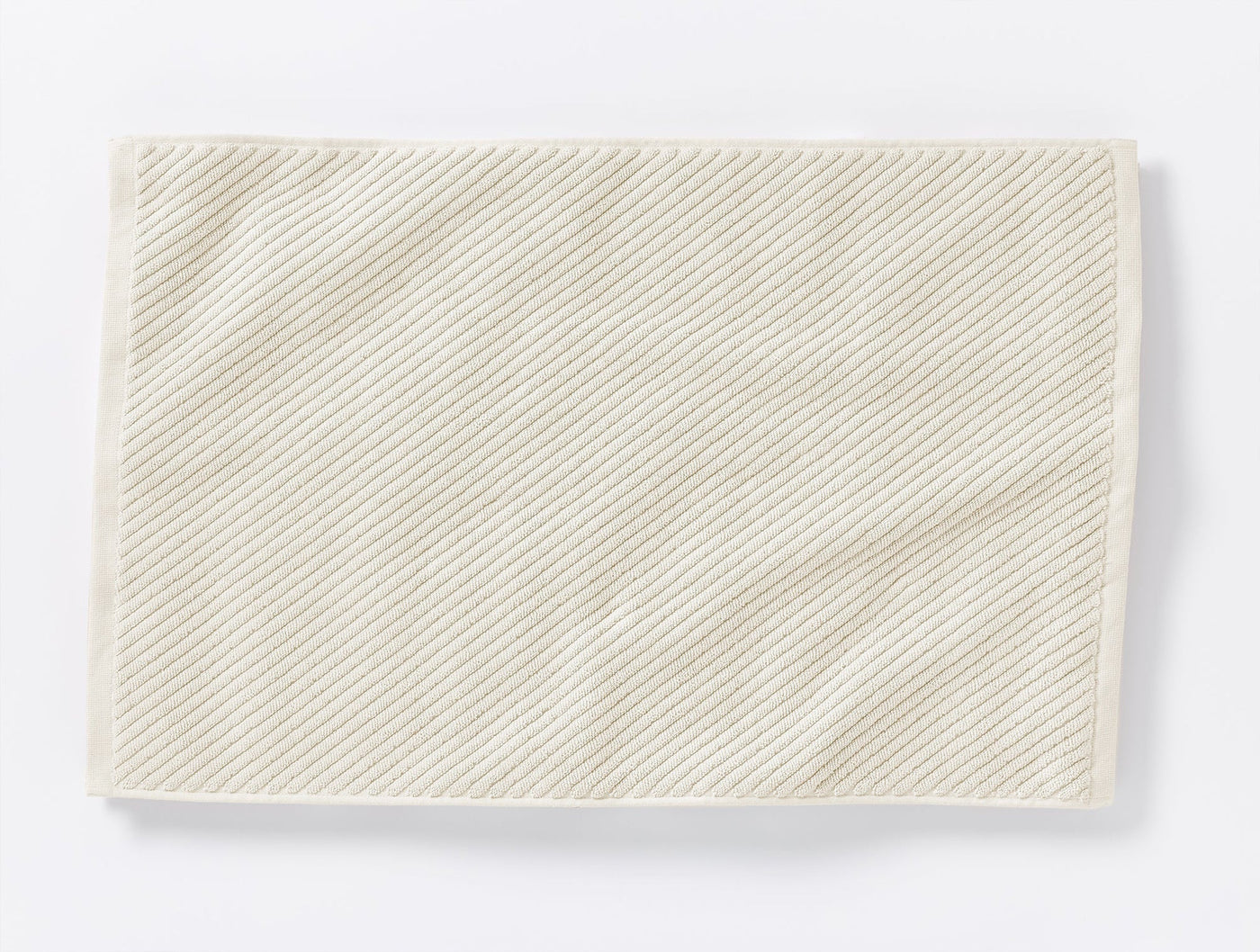 Close-up of Coyuchi Air Weight bath rug showing diagonal twill stripe weave in ivory.