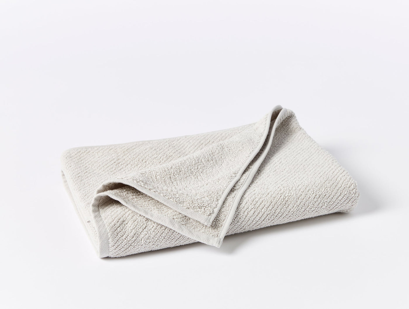 Coyuchi Air Weight wash cloth folded flat, showing natural undyed terry texture.