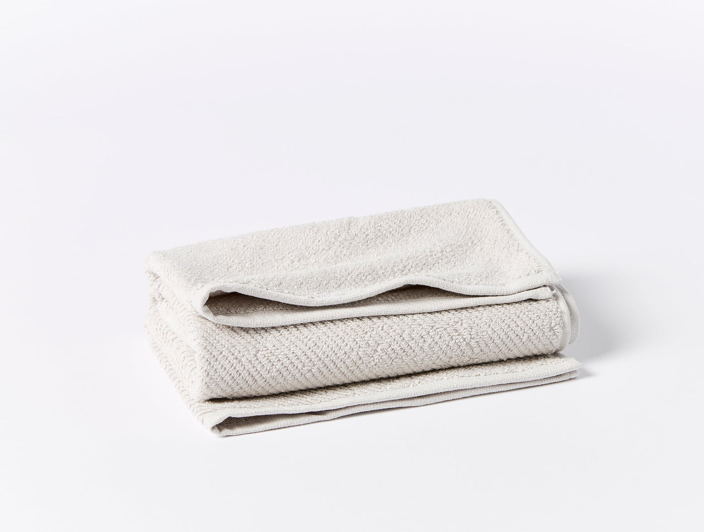 Close-up of folded ivory Coyuchi Air Weight oversized hand towel showing textured weave detail.