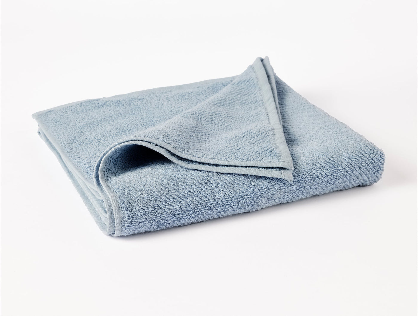Coyuchi Air Weight bath sheet in sky blue, folded to show looped terry texture.